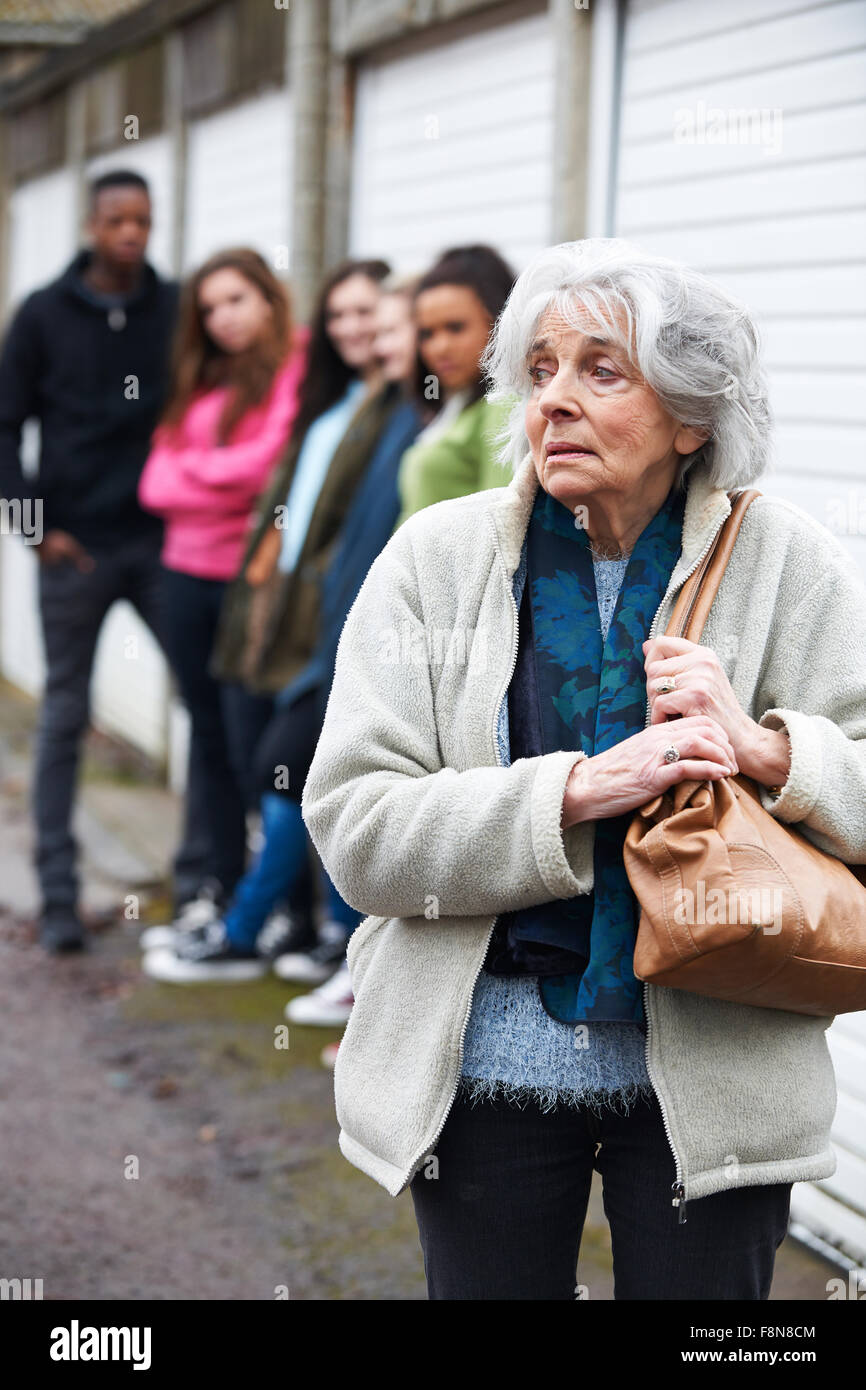 Ältere Frau von Gruppe junger Menschen eingeschüchtert fühlen Stockfoto