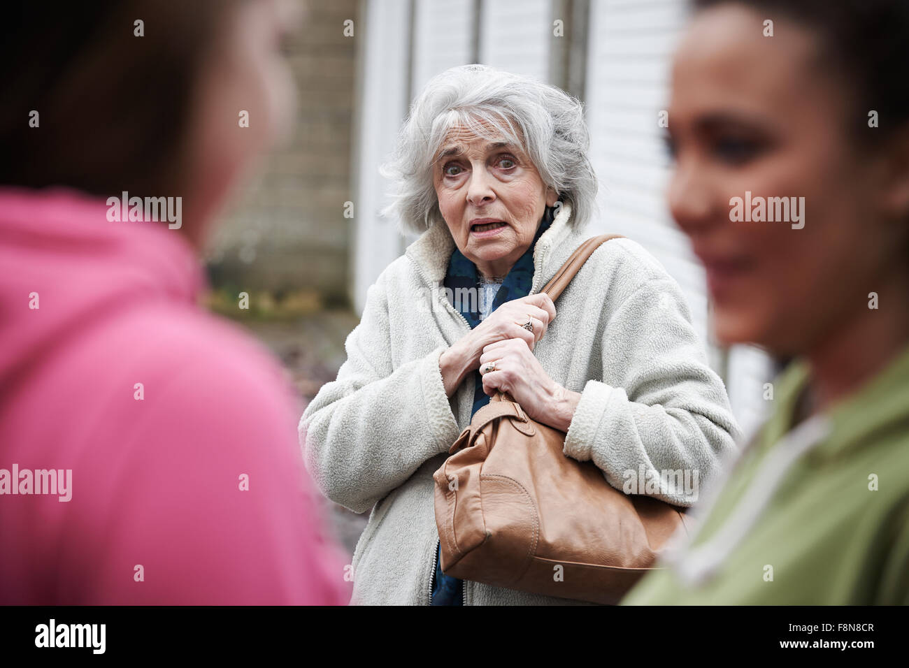 Ältere Frau fühlen eingeschüchtert von Mädchen im Teenageralter Stockfoto