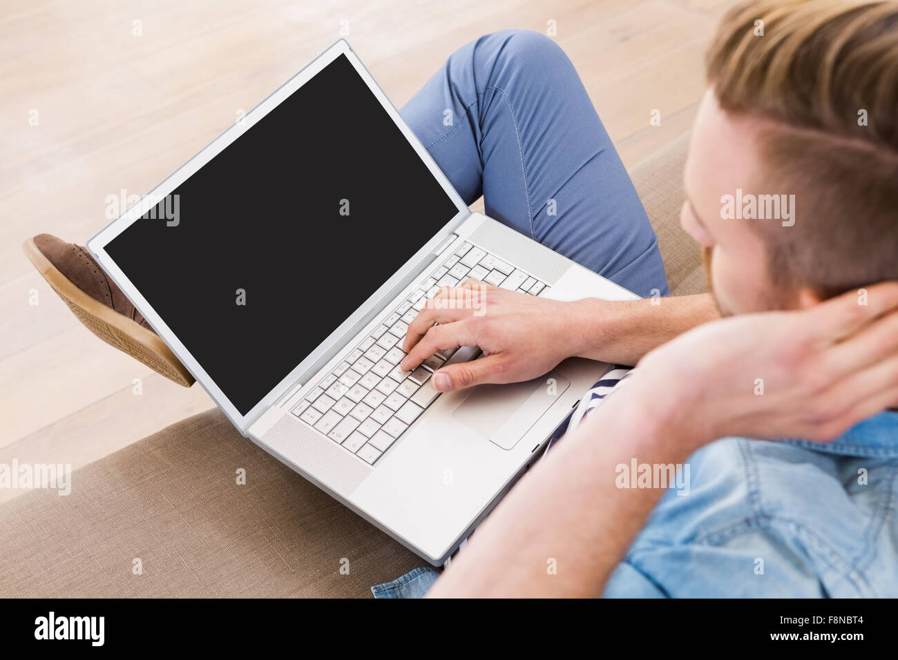 Legerer Mann mit seinem laptop Stockfoto