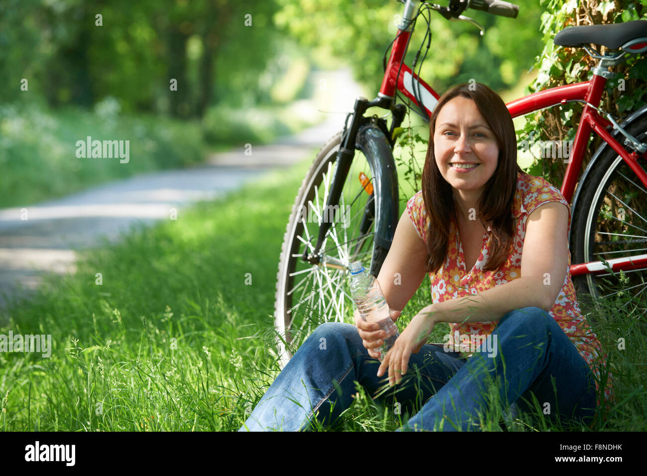 Applying Frau auf Fahrradtour In Landschaft Stockfoto