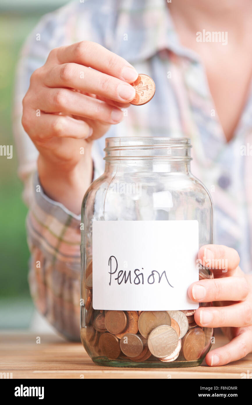 Frau fallen Münzen in Jar gekennzeichneten Pension Stockfoto