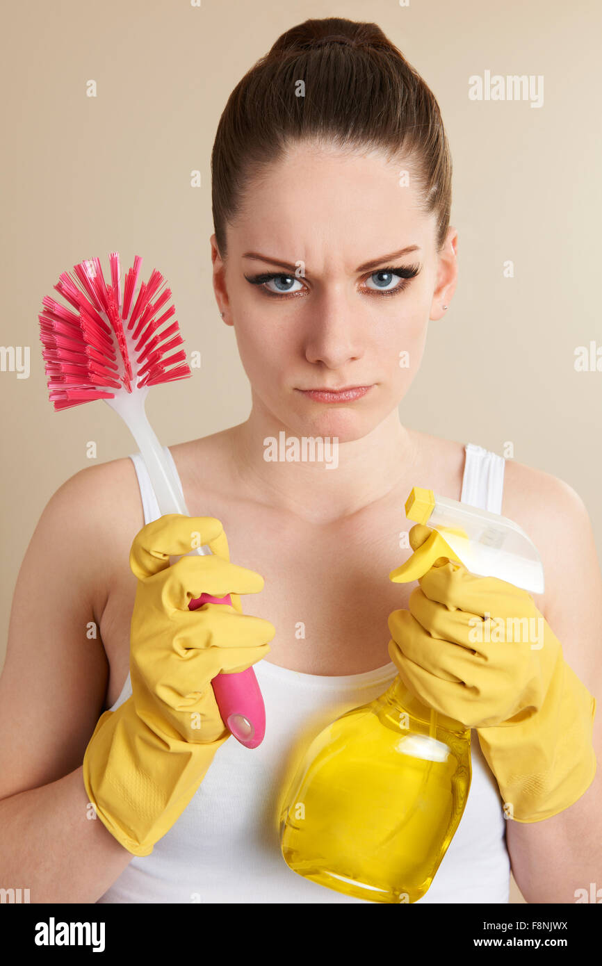 Junge Frau mit Reinigungs-Produkte, die auf der Suche unglücklich Stockfoto