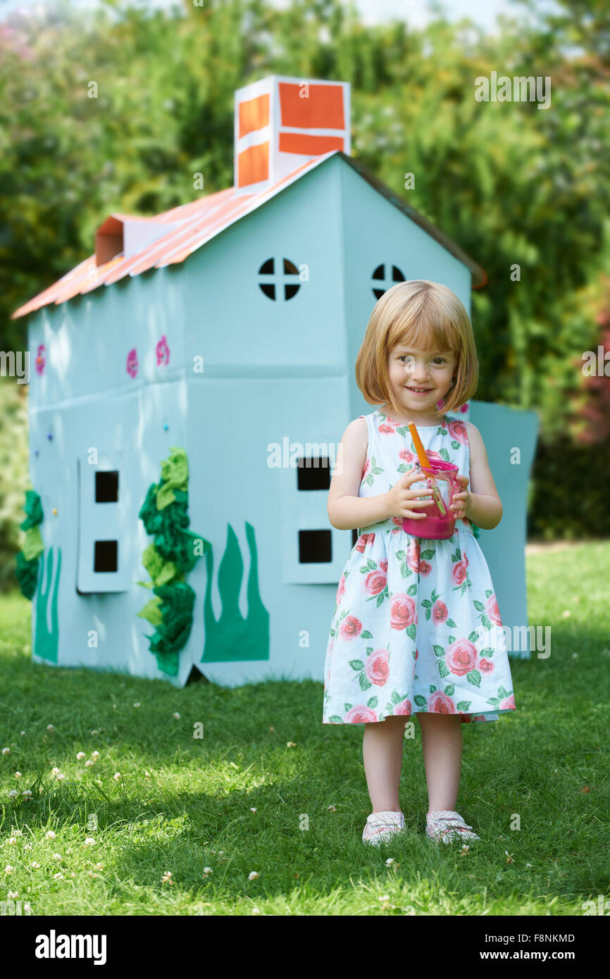Young Girl Malerei hausgemachte Karton-Haus Stockfoto