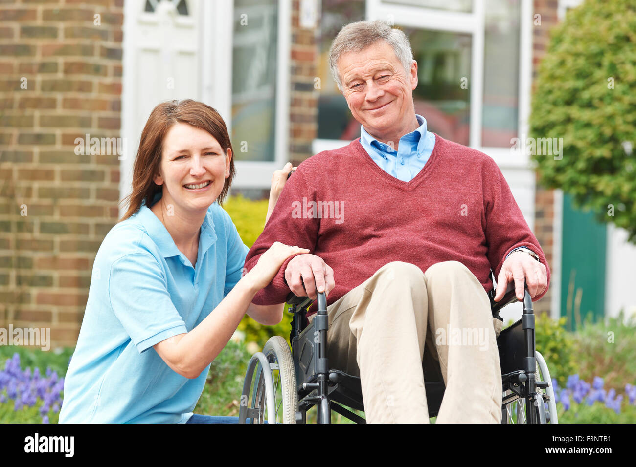 Pflegeperson mit Senior Mann im Rollstuhl Stockfoto
