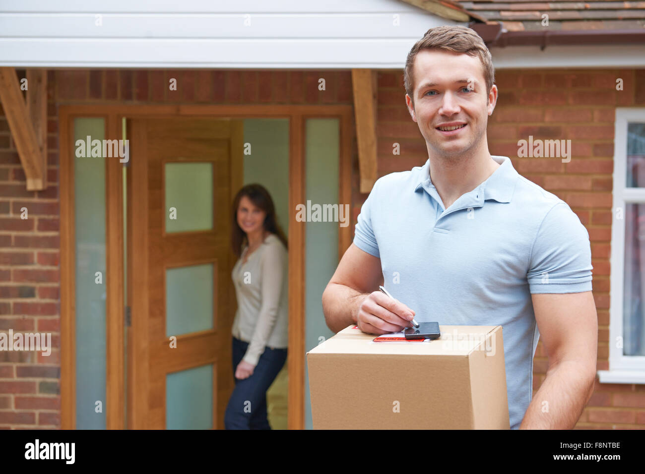 Kurier liefern Paket zu inländischen Haus Stockfoto