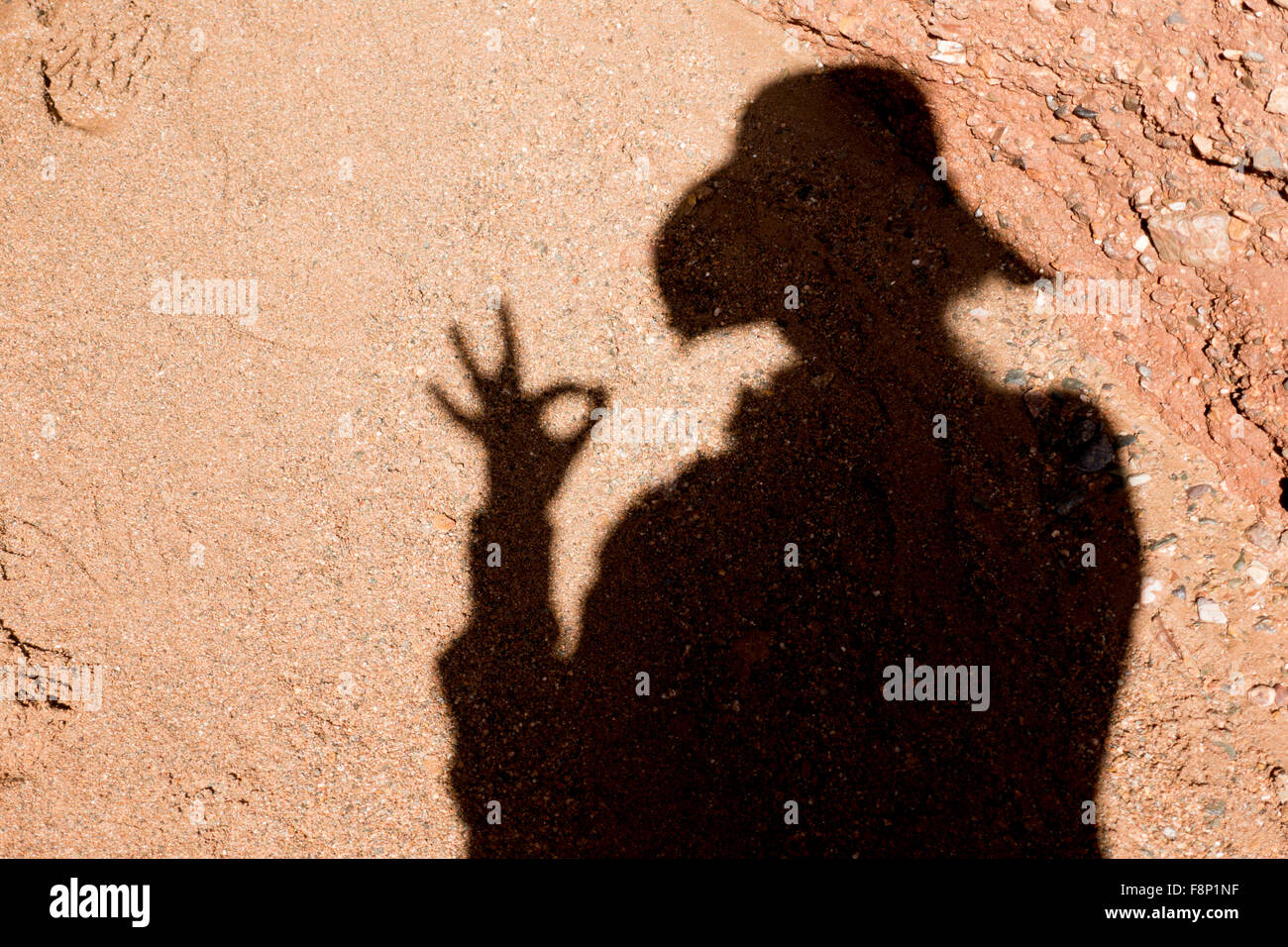Frau Schatten Silhouette auf Sand eine Ordnung Geste Stockfoto