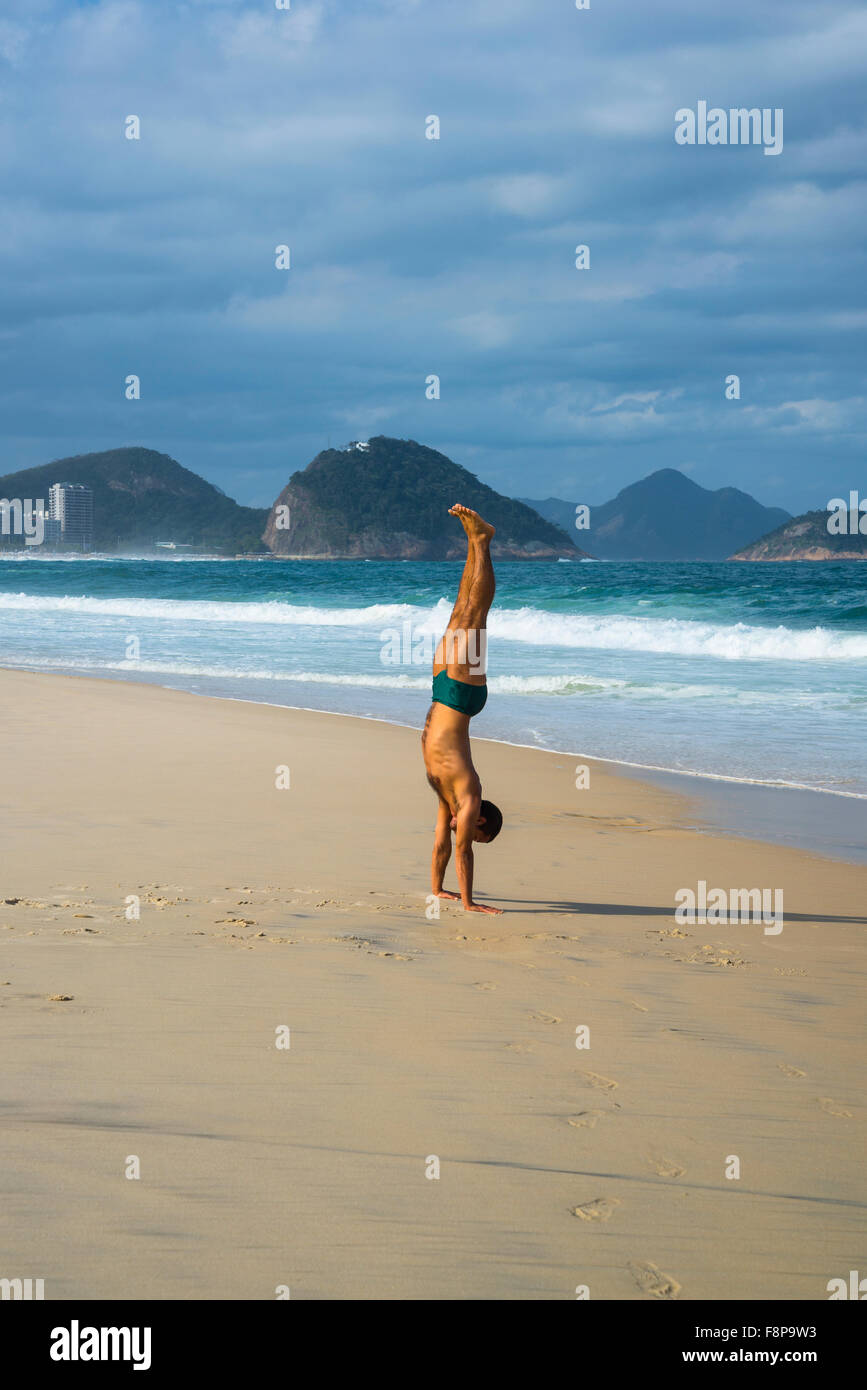 Mann macht einen Handstand, Strand der Copacabana, Rio De Janeiro, Brasilien Stockfoto