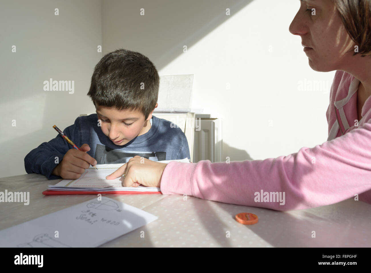 Mutter hilft Kind mit seinen Hausaufgaben, UK Stockfoto