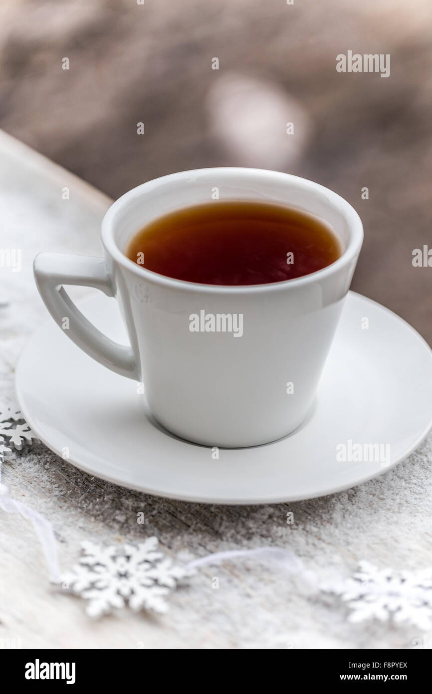 Heißen Tee in weiße Tasse auf schneebedeckten Tisch Stockfoto
