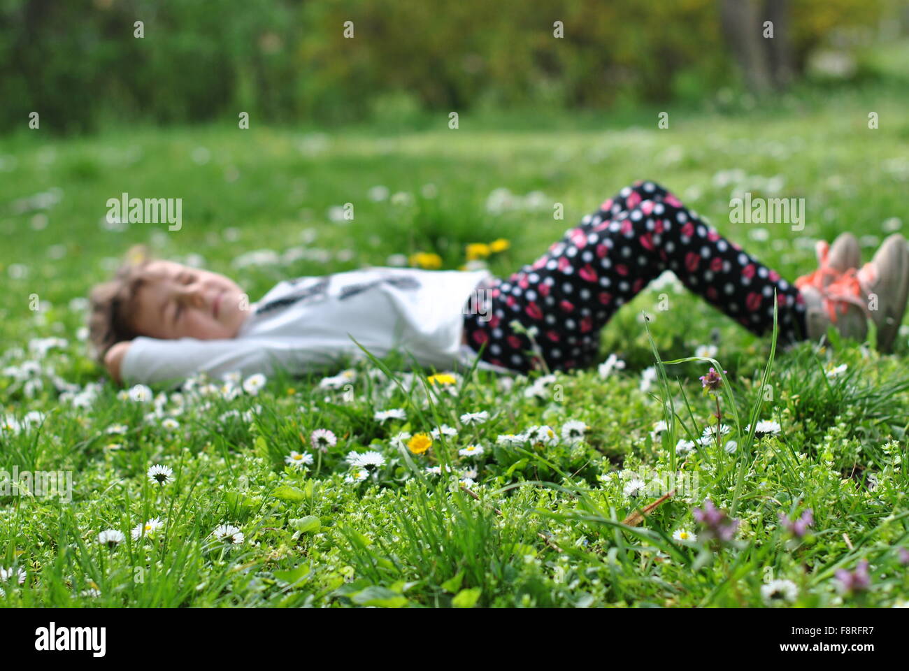 Mädchen liegend auf dem Rasen im Frühling Stockfoto