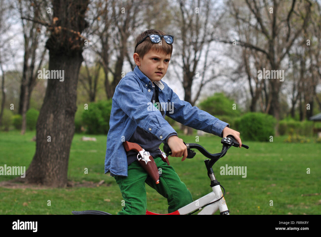 Junge, die vorgibt, ein Polizist auf einem Fahrrad Stockfoto