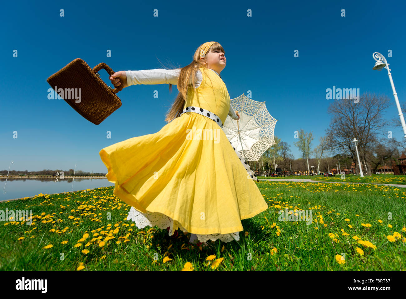 kleine Mädchen spielen in der Natur, genießen Freiheit beim Drehen um ihre eigene Achse Stockfoto