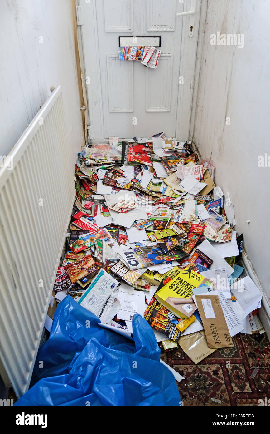 Viele Junk-Mails, Briefe und Broschüren und Flyer, durch einen Briefkasten ein leeres Haus Flur schaffen einen großen Haufen geschoben Stockfoto