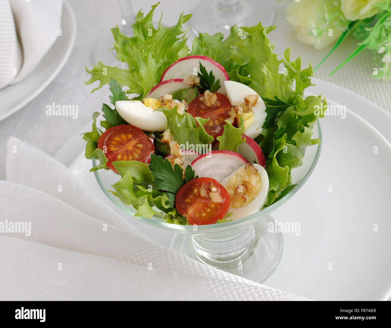 Cherry-Tomaten mit Wachtelei und Radieschen in den Salat Salatblätter Stockfoto