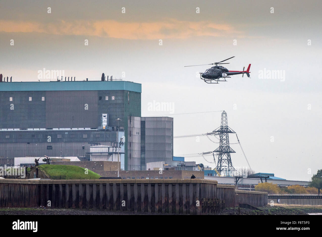 Ein Hubschrauber fliegt über Tilbury B Kraftwerk am Ufer der Themse. Stockfoto