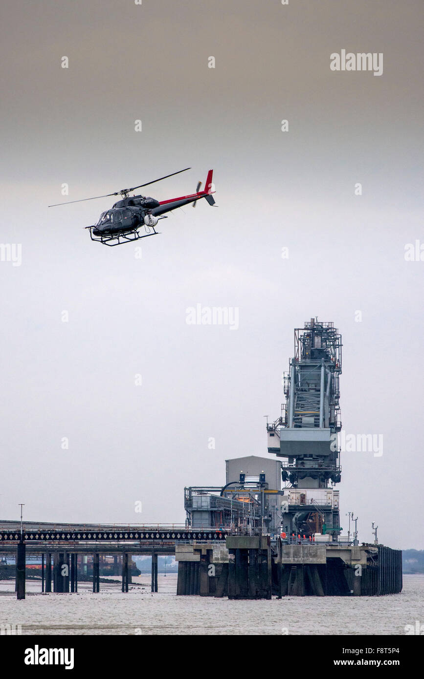 Ein Hubschrauber fliegt über Tilbury B Kraftwerk am Ufer der Themse. Stockfoto