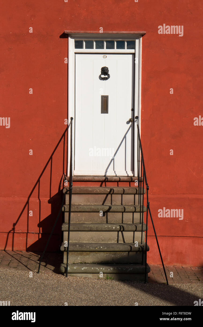 Detail der eine weiße Tür auf rot-Orange lackiert Hütte in Lavenham Suffolk England Stockfoto