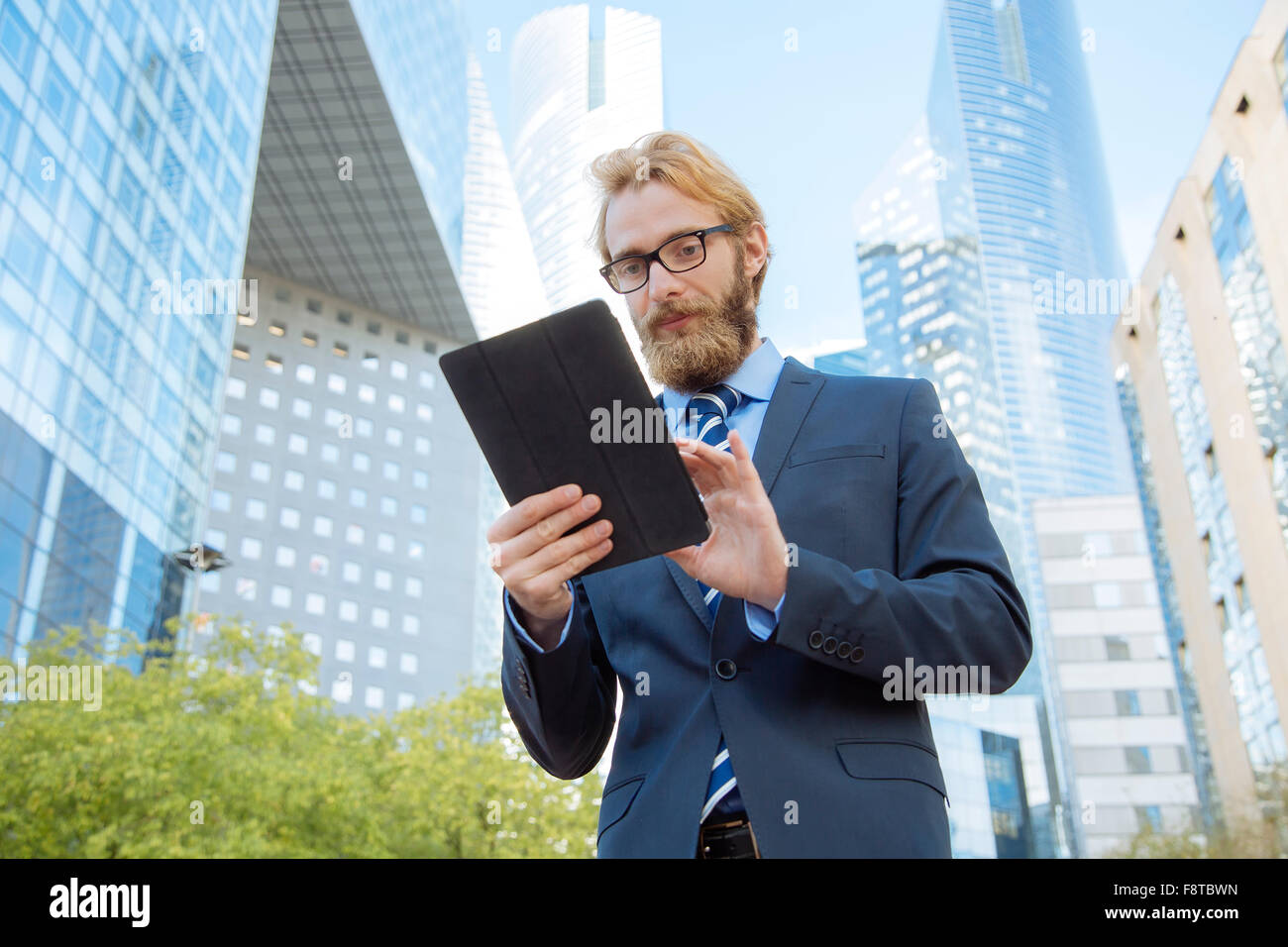 Geschäftsmann mit einem digitalen Tablet im Bankenviertel Stockfoto