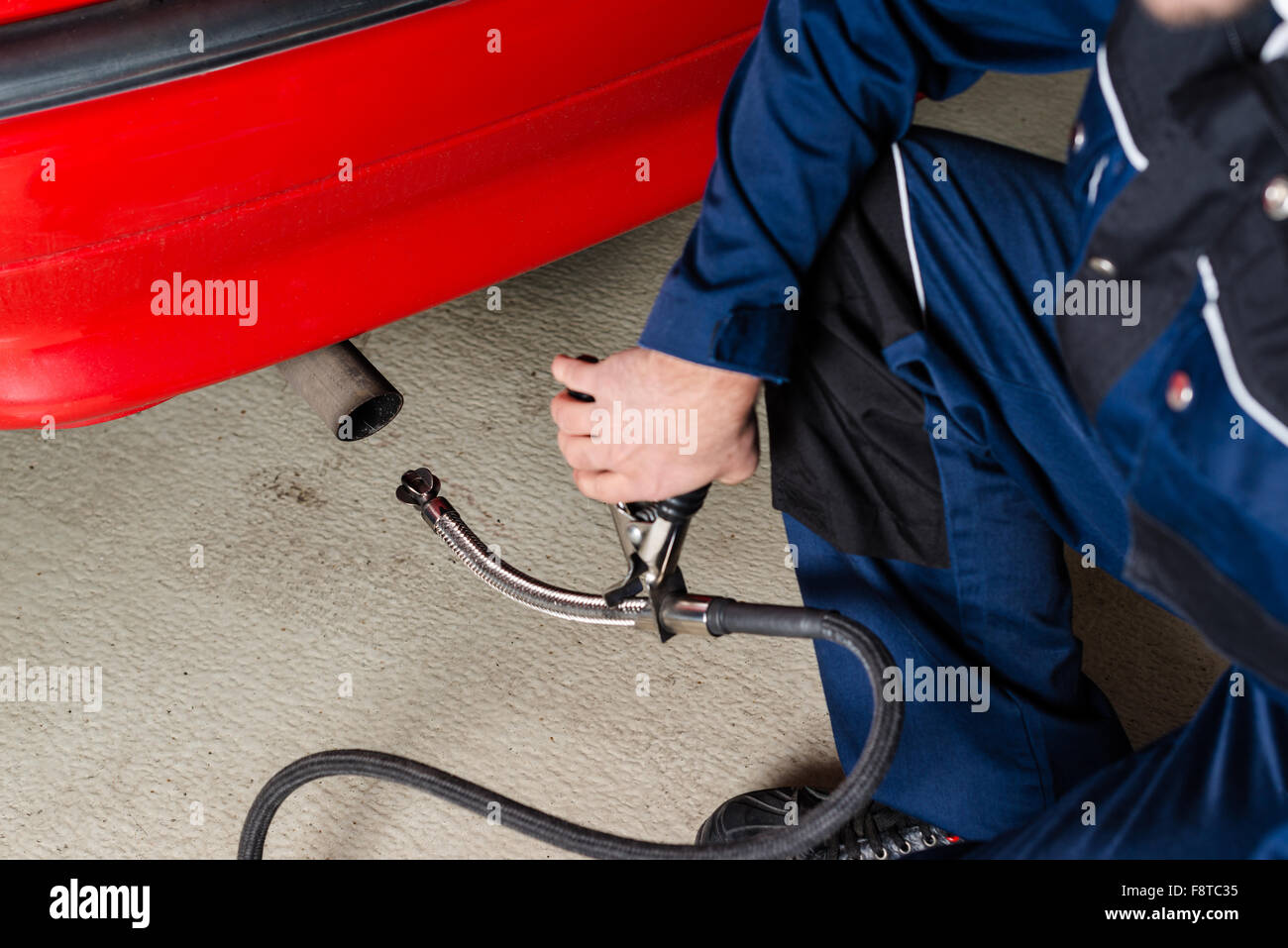 Mechaniker, die Messung der Abgase von einem Auto in garage Stockfoto