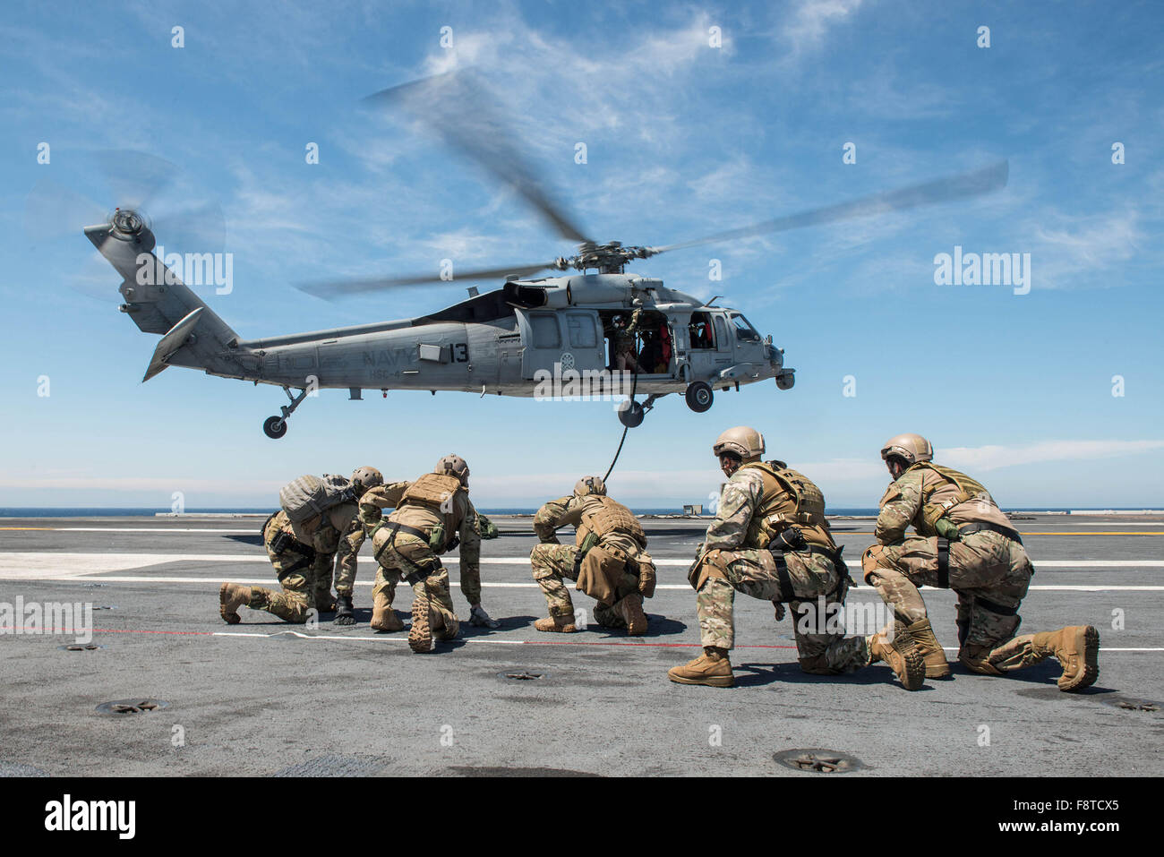 Segler, Explosive Ordnance Entsorgung Mobile Einheit (EODMU) 3, Platoon 3-1-1 und chilenische Marine Matrosen zugewiesen stemmen sich nach Fast-roping aus einem MH-60 Seahawk Hubschrauber, der Hubschrauberstaffel Meer zu bekämpfen, "Black Knights" zugewiesen Stockfoto