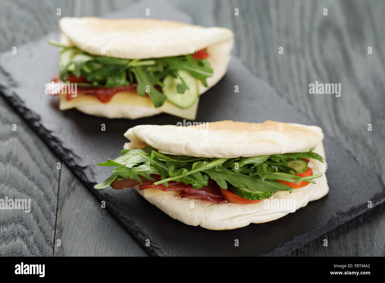 rustikale Sandwiches mit Schinken, Rucola und Tomaten im Fladenbrot Stockfoto