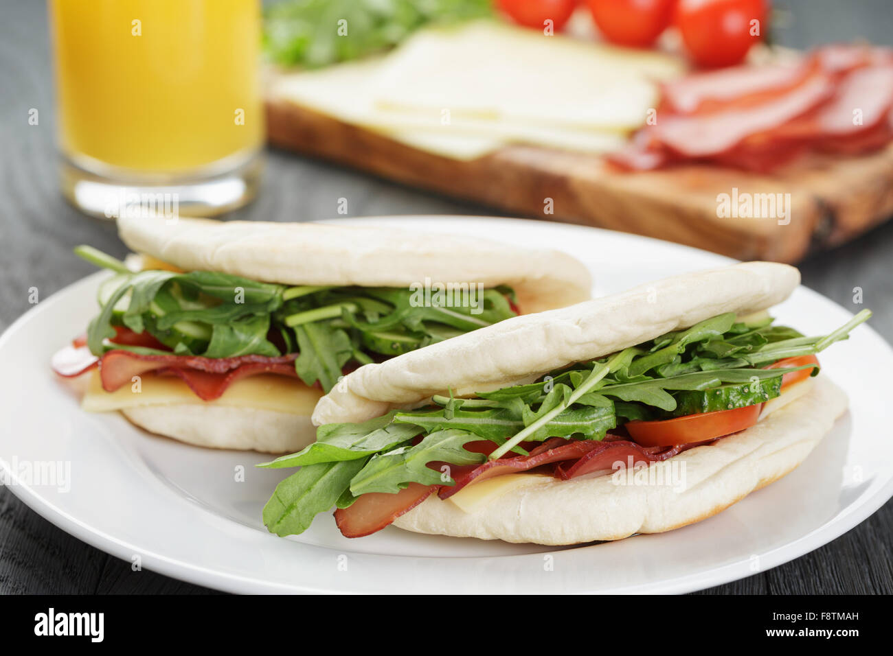rustikale Sandwiches mit Schinken, Rucola und Tomaten im Fladenbrot Stockfoto