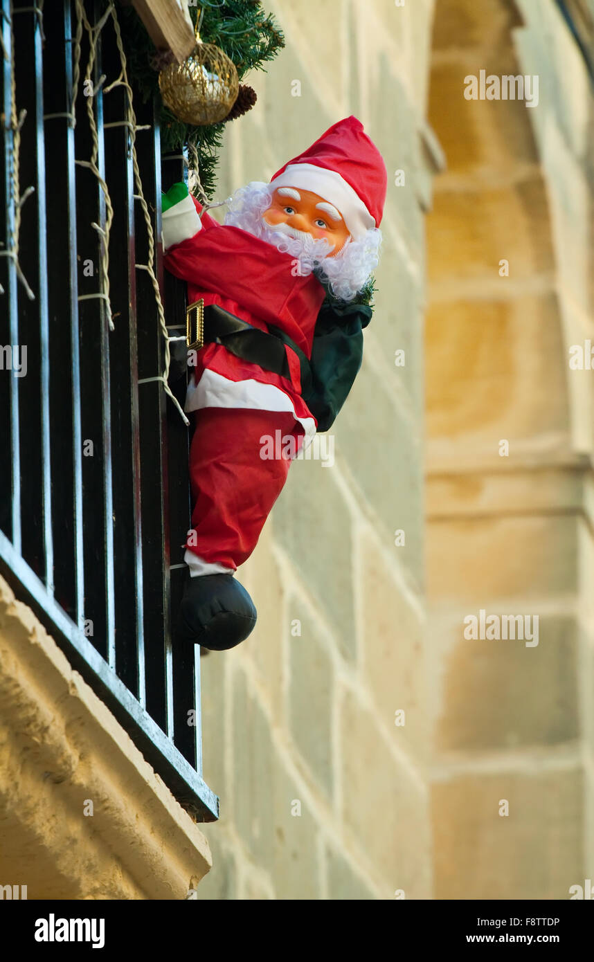 Santa Claus klettert Hauswand am europäischen Stadt Stockfoto