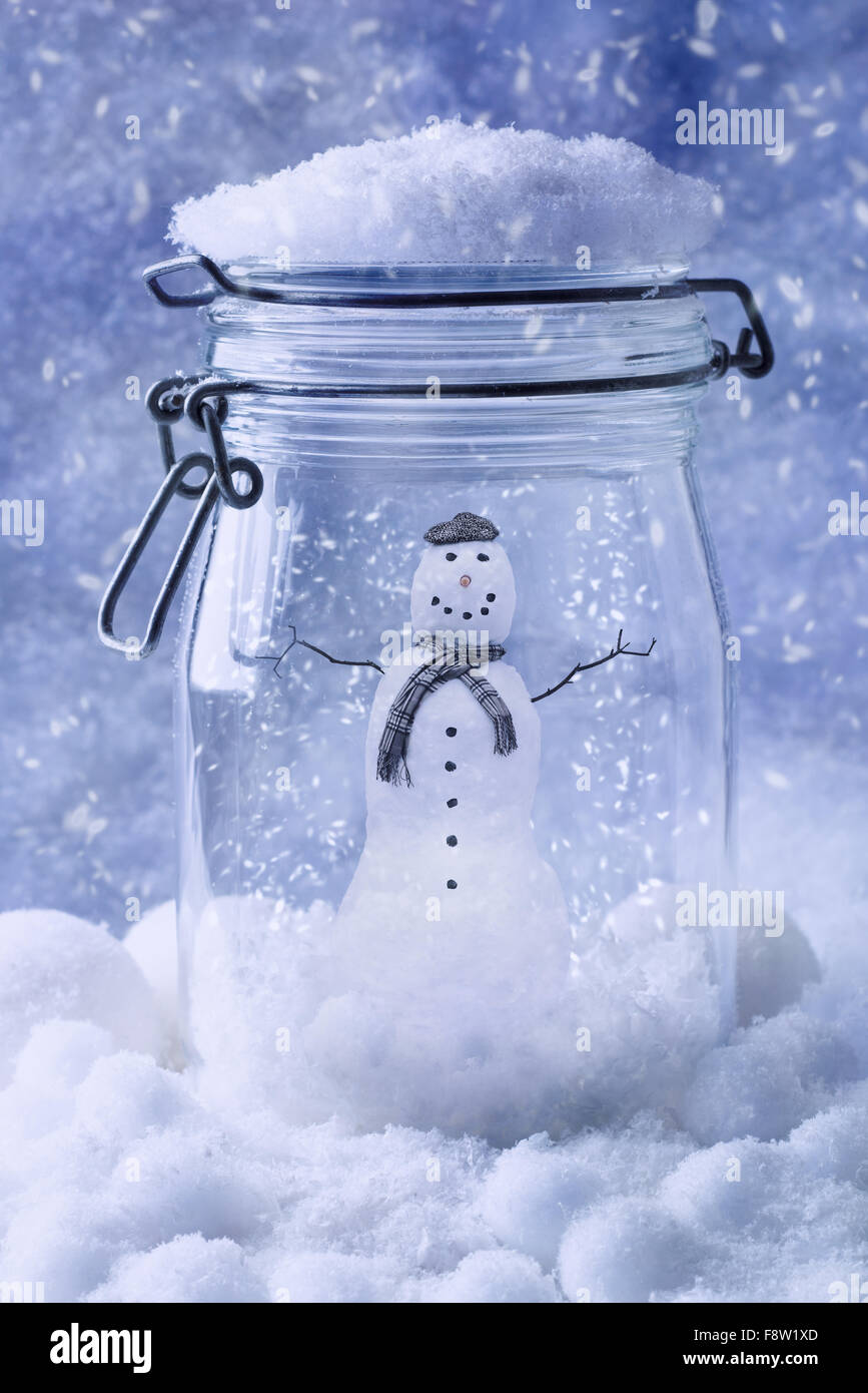 Schneemann in Glas mit Schneefall - Blau-Ton-Effekt hinzugefügt Stockfoto