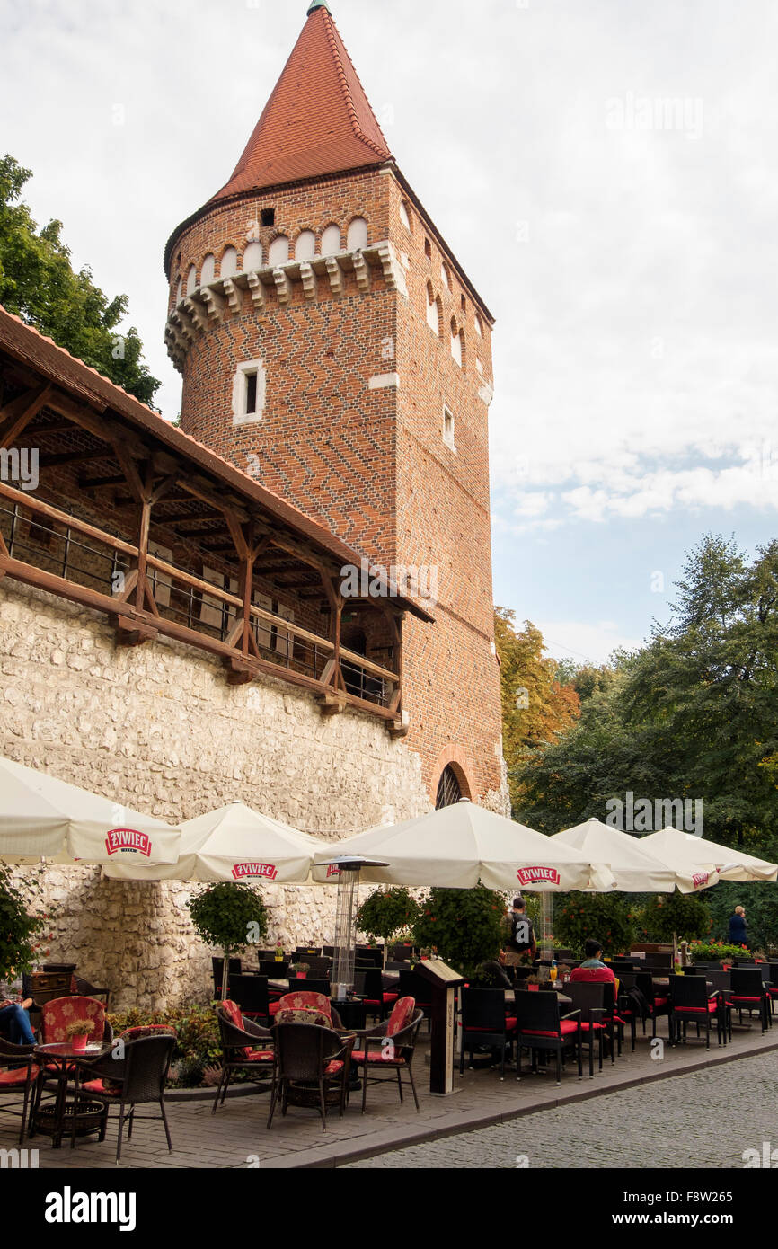 Straßencafé unter Turm in alten Stadtmauern mit überdachten Gang. Krakau, Polen, Europa Stockfoto