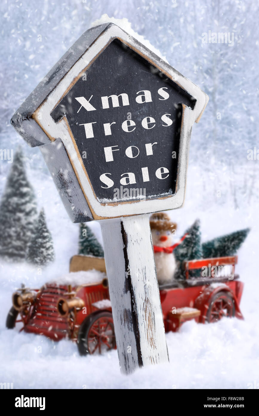 Weihnachtsbäume zu verkaufen melden Sie mit Vintage roten Lieferwagen mit Bäumen im Hintergrund Stockfoto