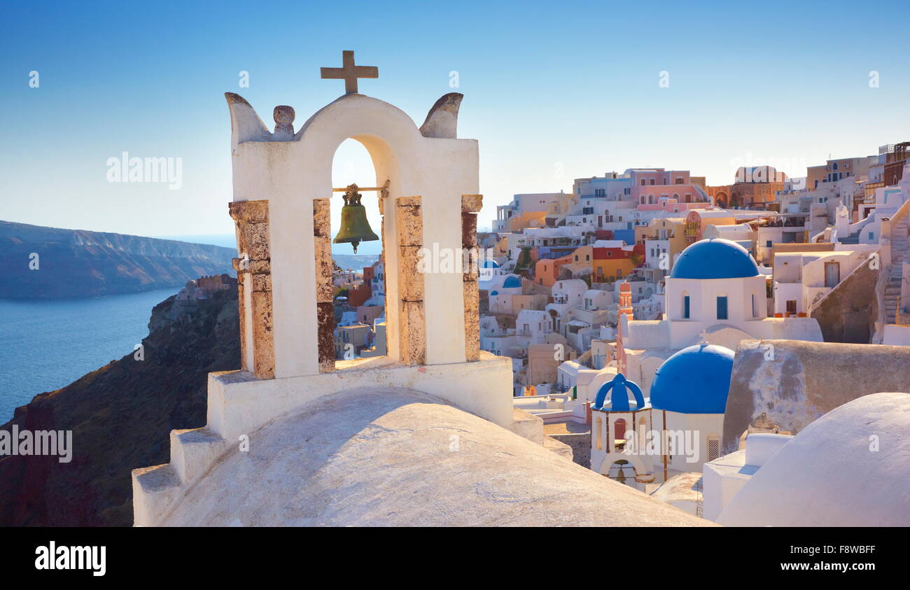 Insel Santorini - griechische Kirche, Glockenturm und weißen Häusern im Hintergrund - Stadt Oia, Griechenland Stockfoto