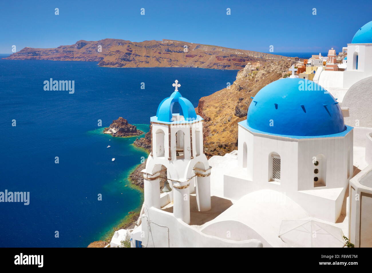 Santorini-Landschaft mit griechischen Bell Tower und weiße Kirche mit blauer Kuppel mit Blick aufs Meer, Oia, Santorin, Griechenland Stockfoto