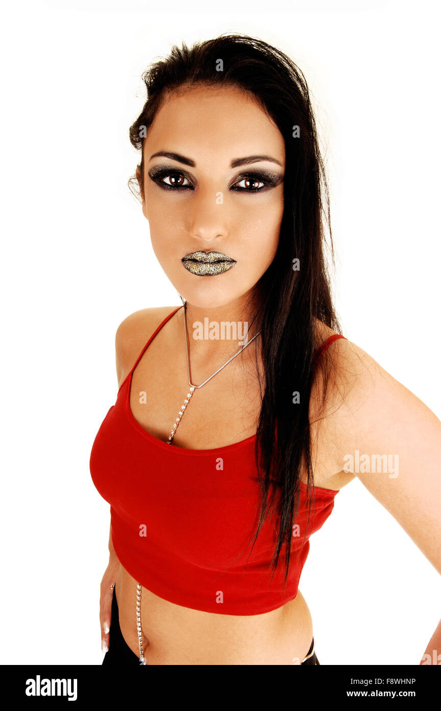 Ein junges Teen Mädchen in einem roten Top, mit langen schwarzen Haaren steht für weißen Hintergrund, Blick in die Kamera, mit schwarzen Lippen. Stockfoto