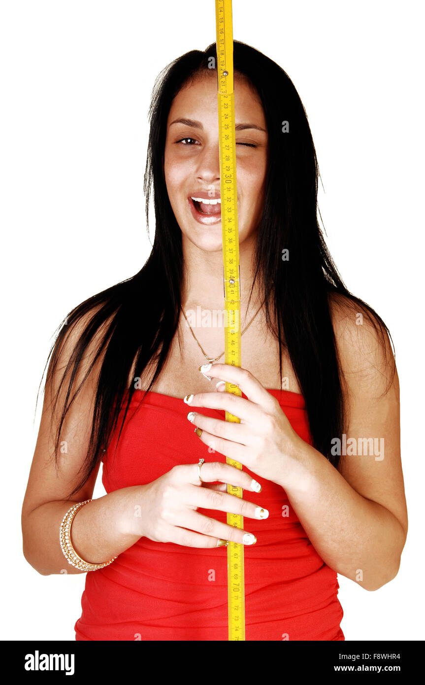 Ein hübsches Lachen Teen Mädchen und weißem Hintergrund stehen und hält eine gelbe Messlatte für ihr Gesicht. Stockfoto