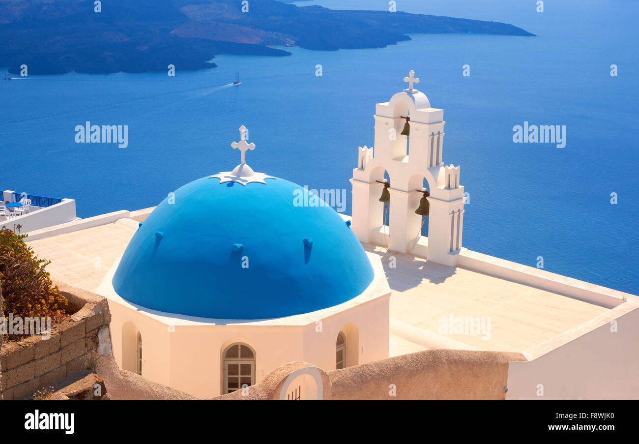 Thira (Hauptstadt von Santorini) - Blick auf griechische Kirche mit blauer Kuppel, Glockenturm und blaues Meer, Insel Santorin, Kykladen, Griechenland Stockfoto