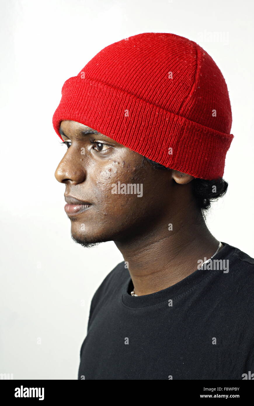 Indischer Mann Seite Porträt mit roter Mütze Hut auf weiß Stockfoto