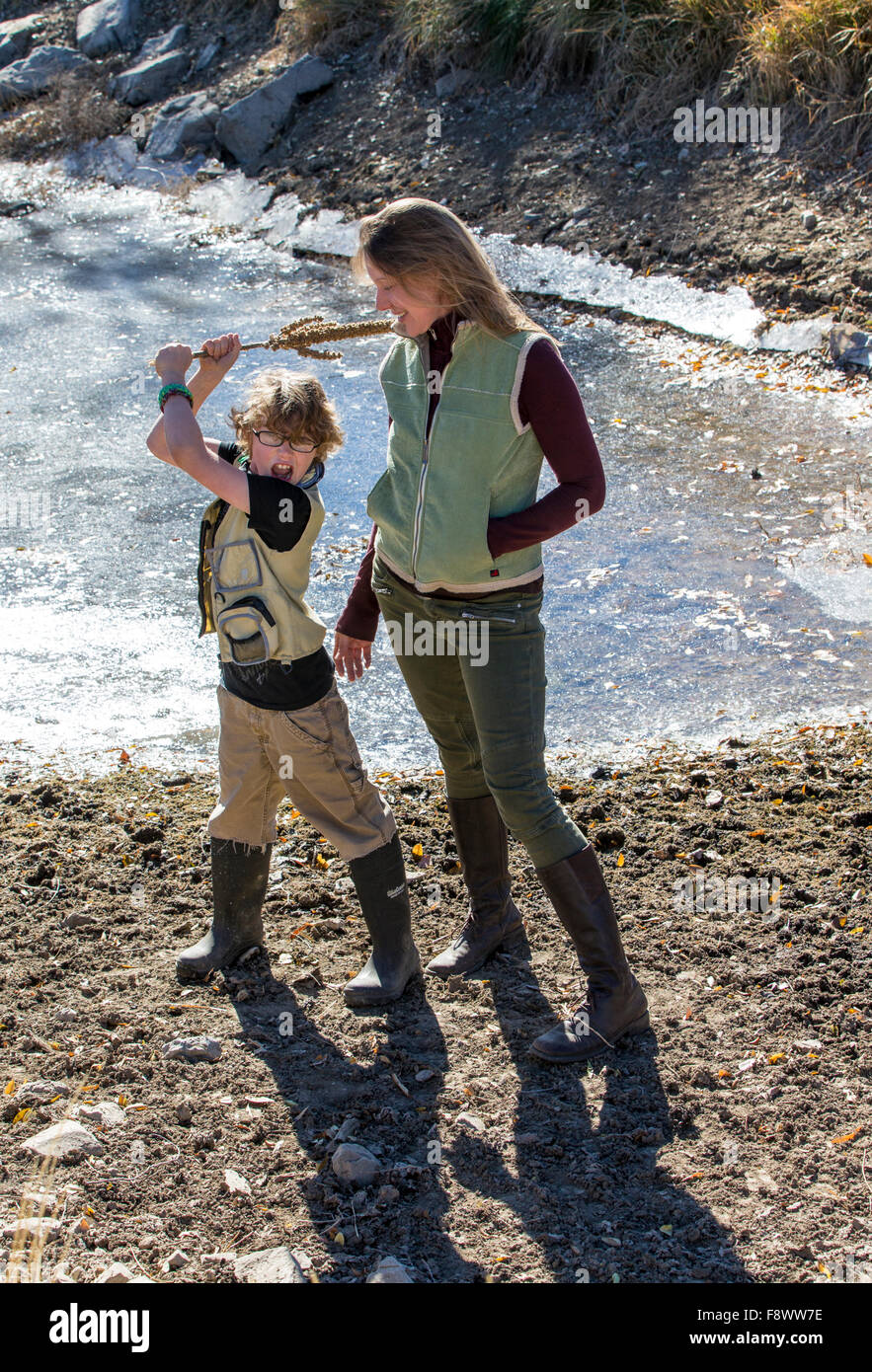 Attraktive Mutter und seinem kleinen Sohn in der Nähe von gefrorenen Teich ranch Stockfoto