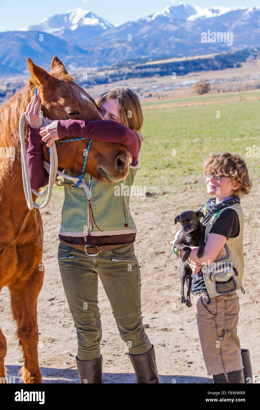Attraktive Mutter; jungen Sohn; Pferd und Hund posieren außerhalb auf Ranch für ein Foto Stockfoto