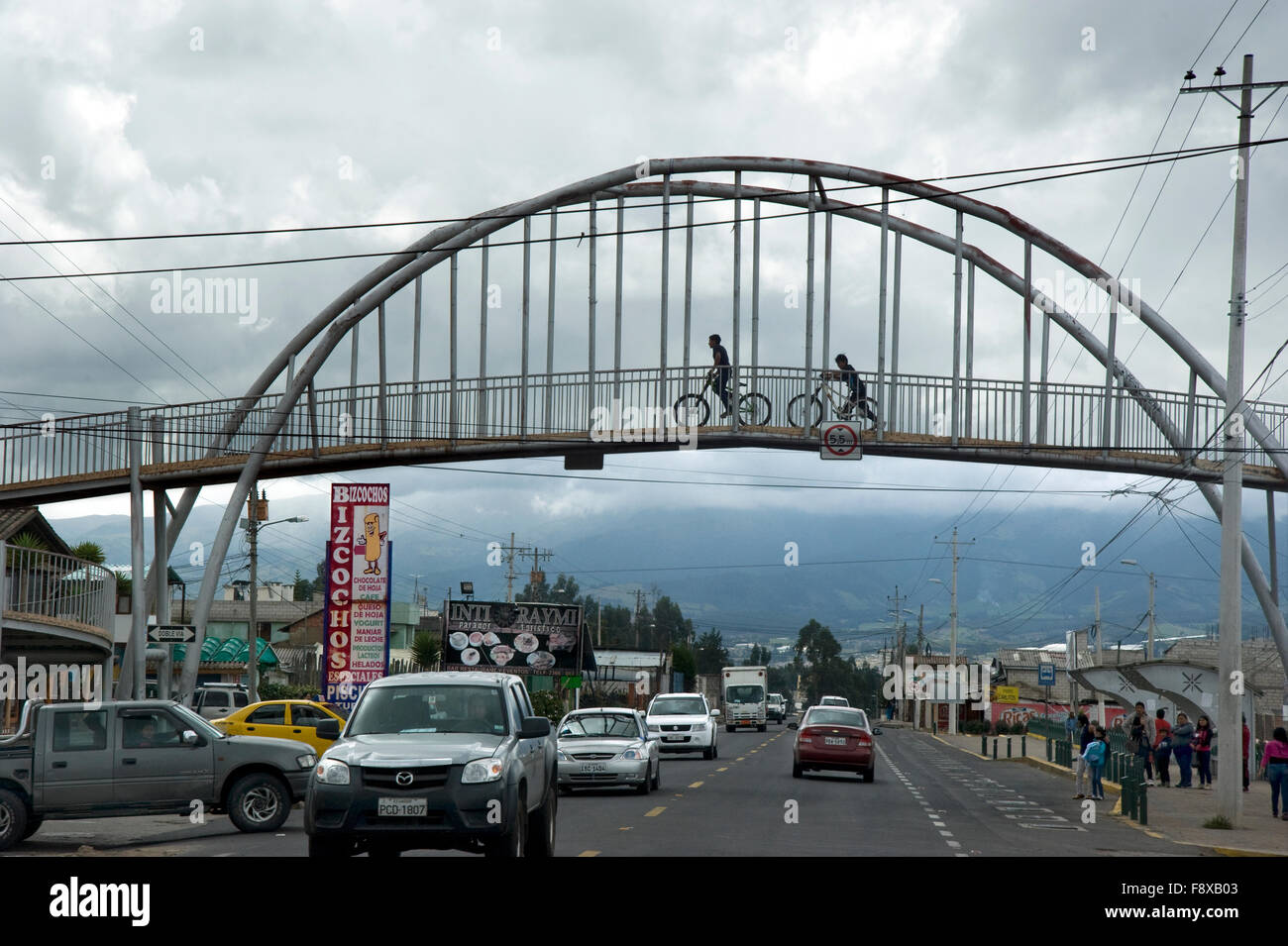Kinder fahren Fahrrad über Brücke über Road außerhalb von Quito, Equador Stockfoto