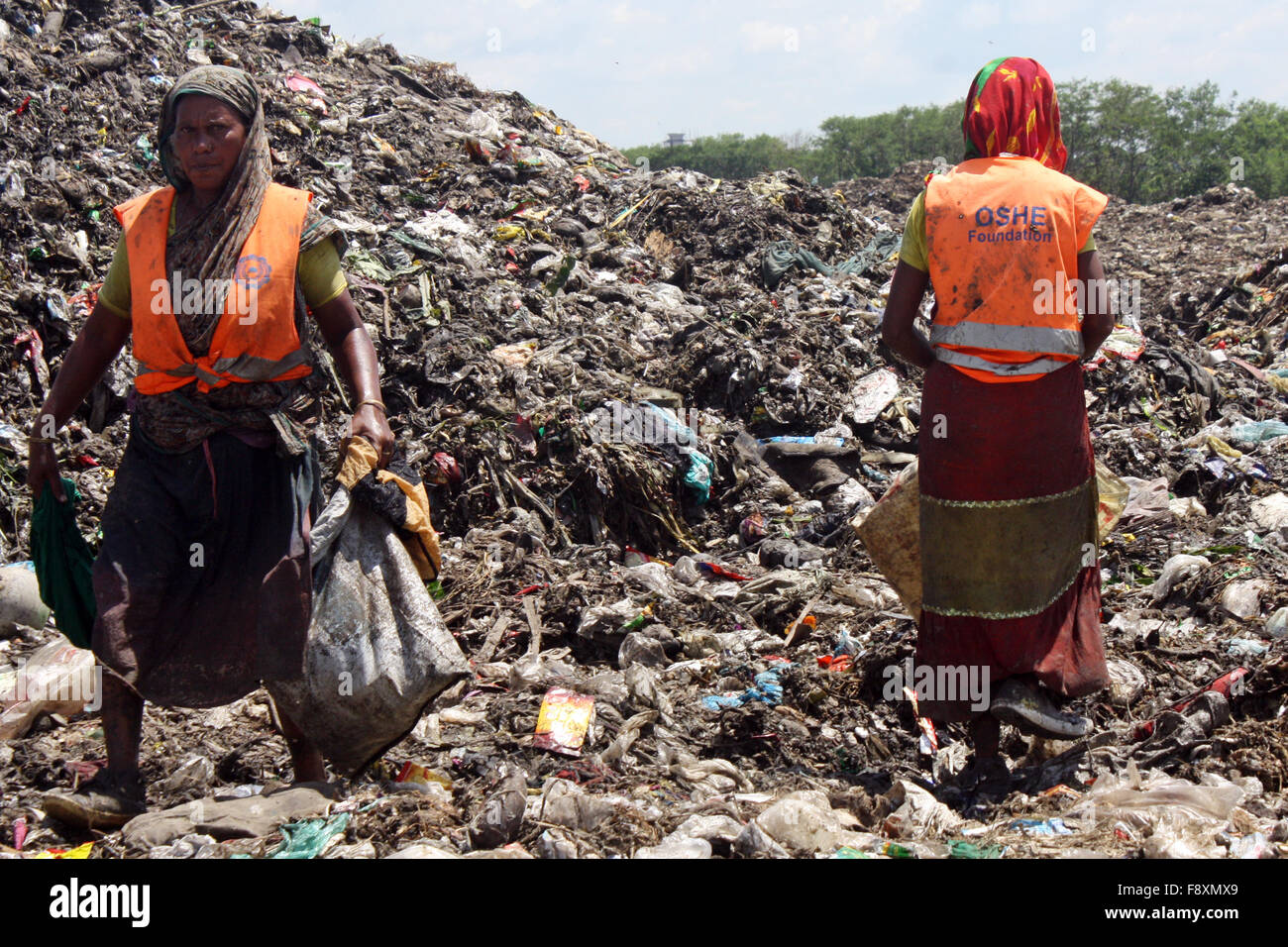 Männliche und weibliche waste Pickers holen die nicht biologisch abbaubare Abfälle für die Recyclingindustrie in Abfall Dump Hof verwendet werden. Stockfoto