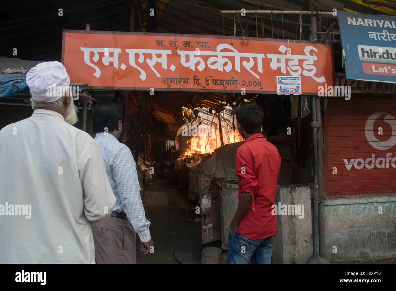 Nerul, Indien 12. Dezember 2015. Die Menschen sehen ein Feuer, dass Engulfyed, die mehrere Geschäfte auf dem Фекиром Markt zur Jama Masjid in Sektor 15, Nerul, Navi Mumbai schließen. Bildnachweis: Tapas Ganesh/Alamy Live-Nachrichten Stockfoto