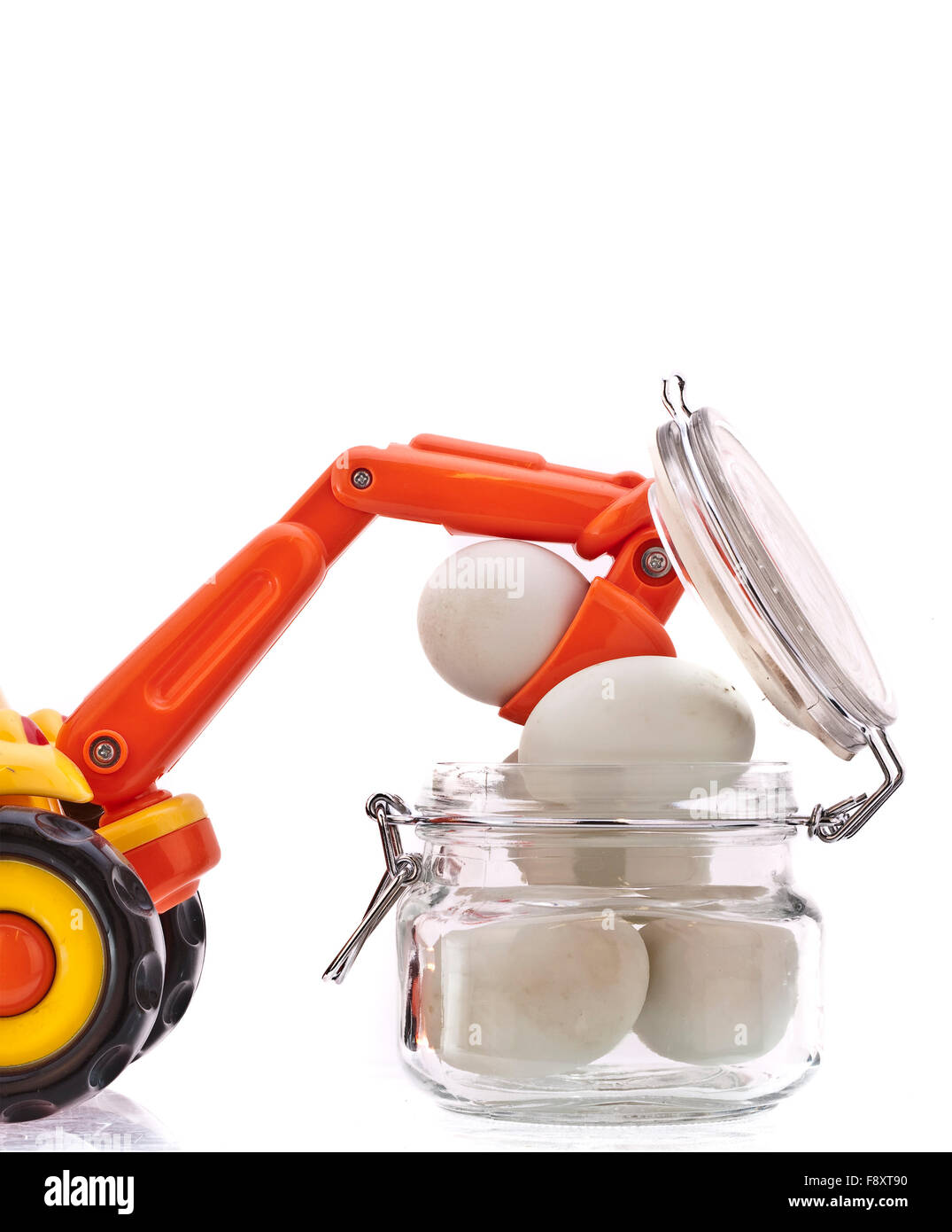 Arbeiten mit Eiern, Spielzeug Bagger hebt Eiern aus der Quarantäne Jar auf weißem Hintergrund Stockfoto