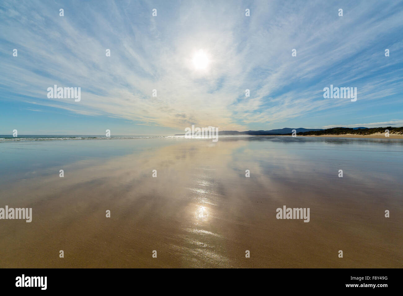 Himmel und Wolken Reflexion am Ufer eines Strandes. Stockfoto