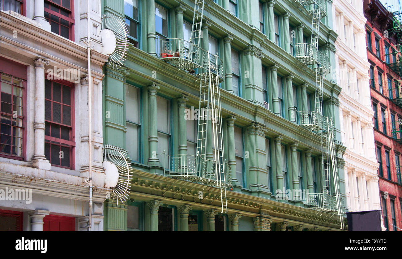 Vier bunte, grau, grün, weiß und rot Mehrfamilienhäuser Fassaden mit Notfall entweicht. Typische New Yorker Vermietung comp Stockfoto