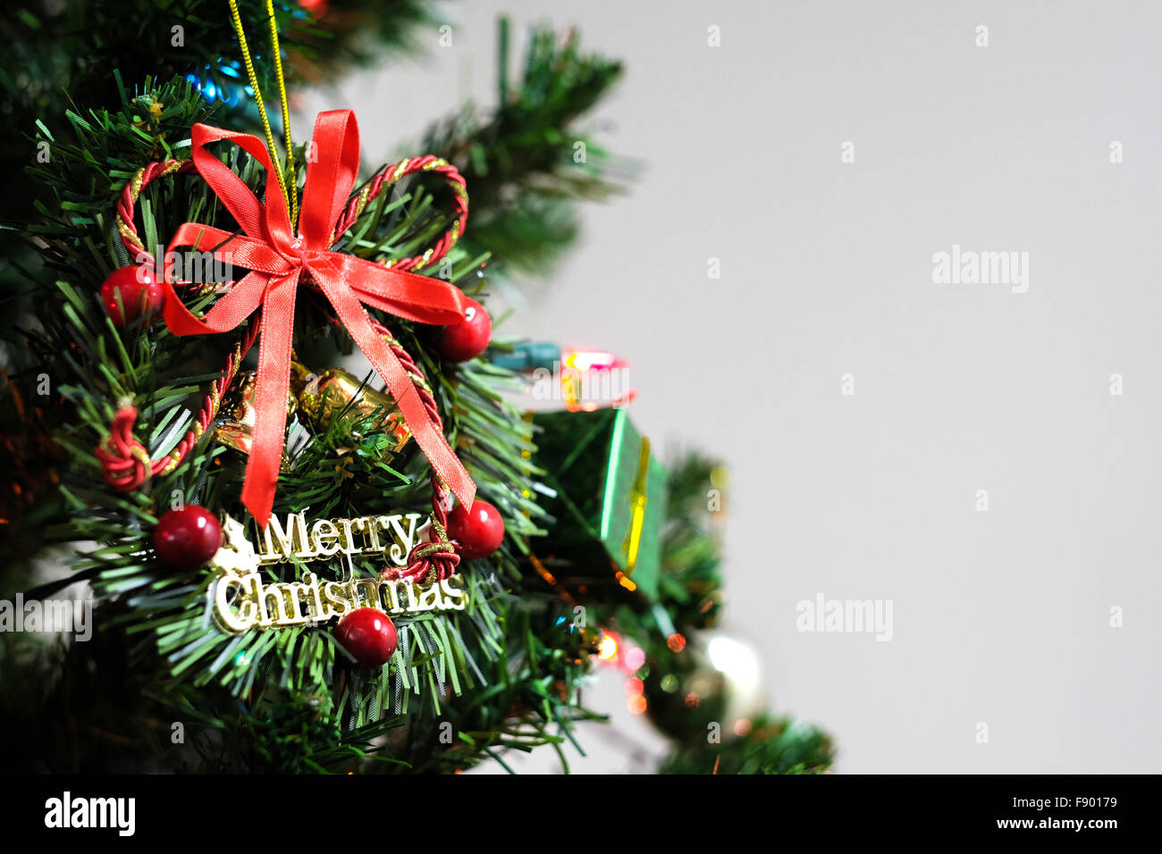 Frohe Weihnachtskranz geschmückt am Weihnachtsbaum mit Exemplar auf weißem Hintergrund Stockfoto