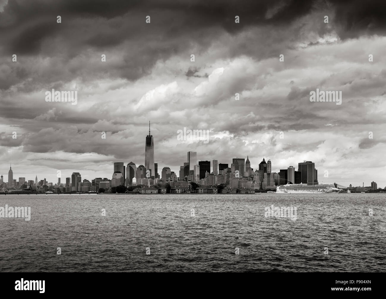 New York Harbor & schwarz-weiß Sicht auf Lower Manhattan, New York. One World Trade Center steigt in Richtung niedrige Wolken Stockfoto