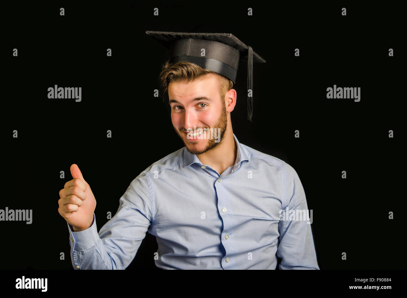 Glücklich Jüngling Abitur, mit Graduierung Hut, dabei Daumen Schild Stockfoto