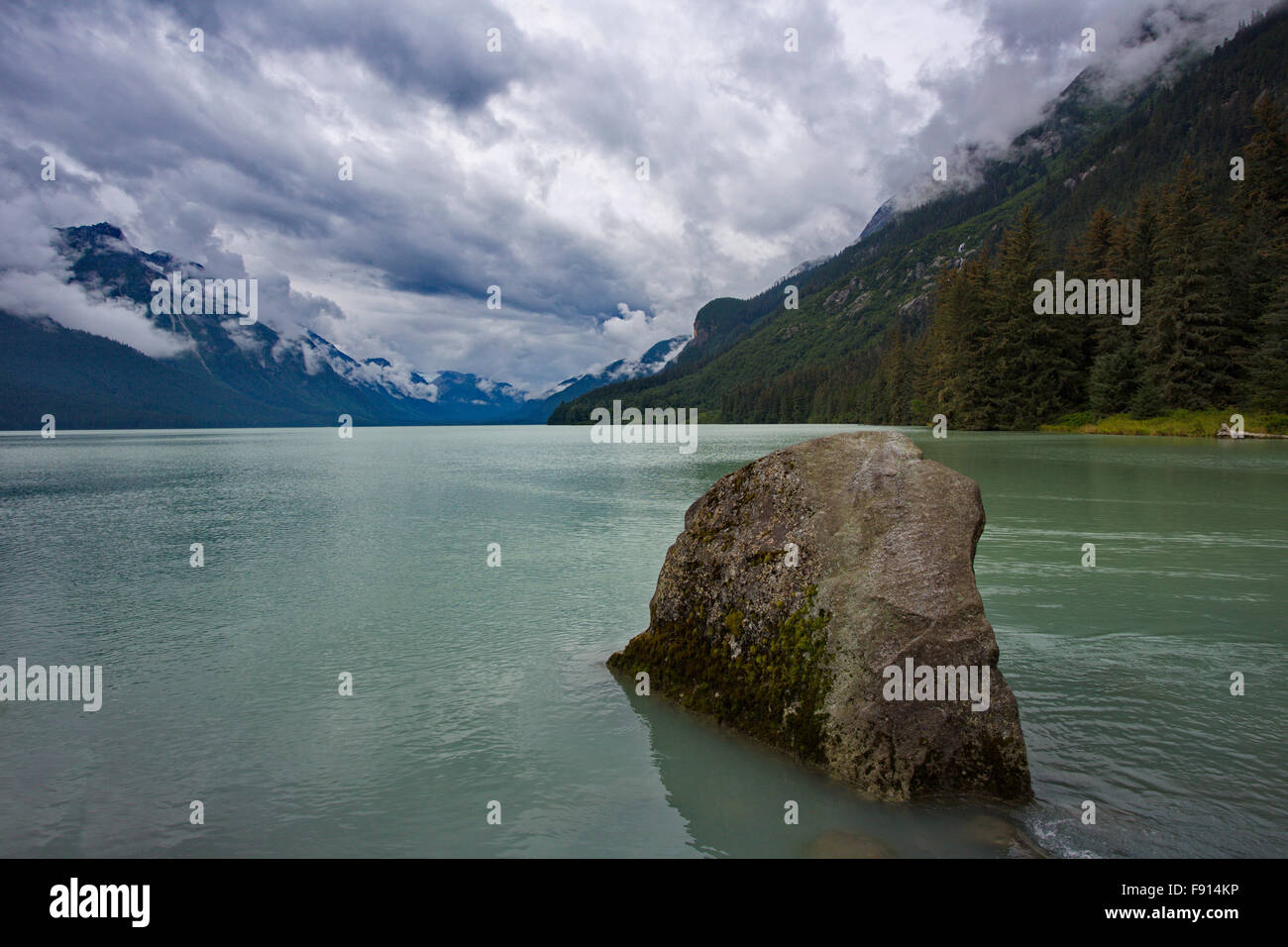 Rock im Vordergrund der heitere Himmel über Chilkoot Lake.  Die Lage ist Haines, Alaska, Vereinigte Staaten von Amerika. Stockfoto