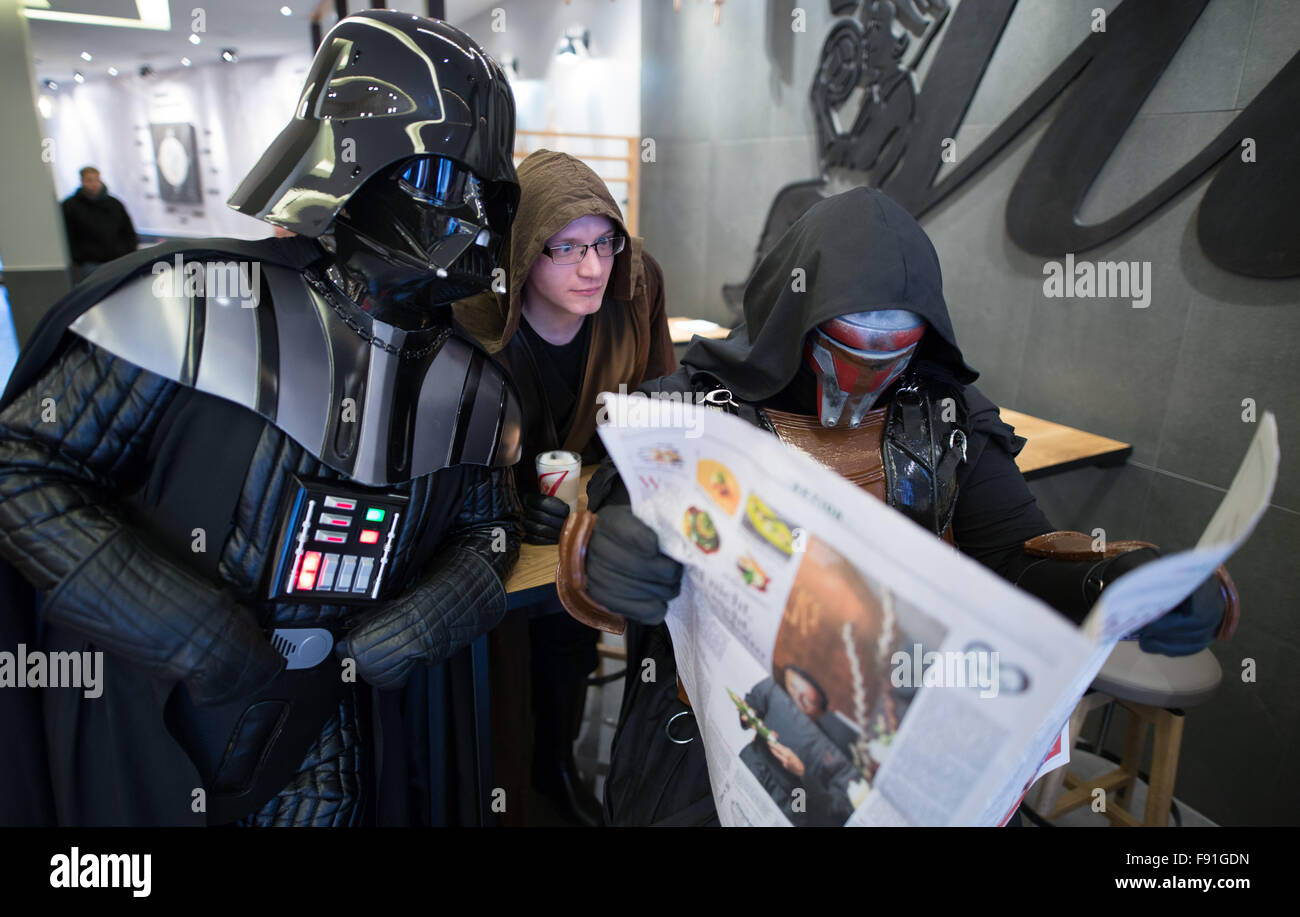 Hamburg, Deutschland. 14. November 2015. Mitglieder der Star Wars-Fan-Club lesen eine Zeitung, wie sie in einem Café in Hamburg, Deutschland, 14. November 2015 als Darth Vader, Jedi und Darth Revan gekleidet sitzen. Teil sieben der Serie "Star Wars – das Erwachen der macht-Premiere in den deutschen Kinos am 17. Dezember 2015. Foto: Axel Heimken/Dpa/Alamy Live News Stockfoto