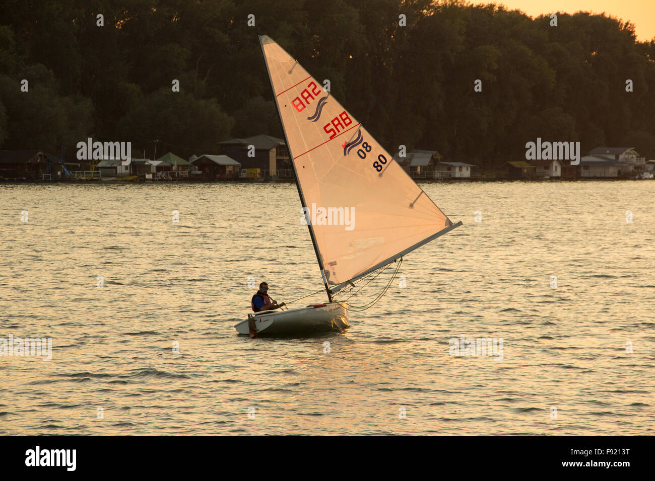 Belgrad, Serbien - Finn-Klasse Yacht Segeln bei Sonnenuntergang Stockfoto